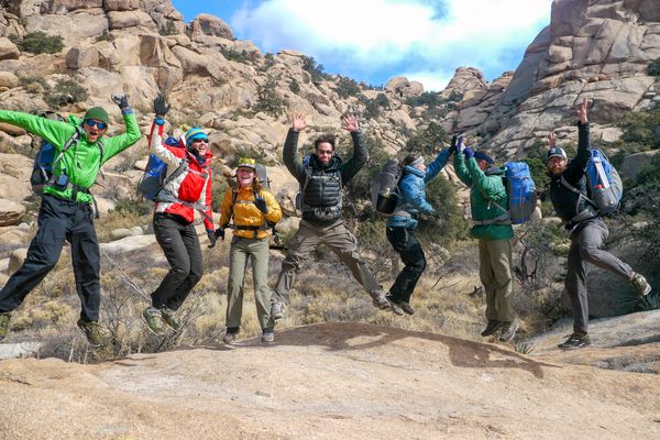 A group of students jumping amidst the rugged desert landscape of the Southwest.