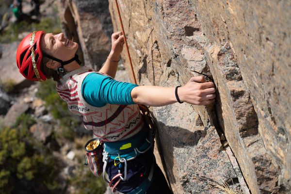 A student laughing while rock climbing in Patagonia.