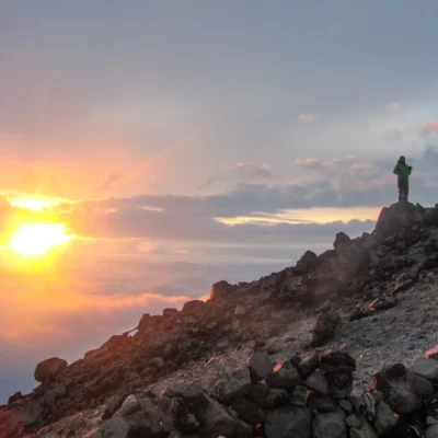 Students watch the sun set from a remote peak in Alaska.