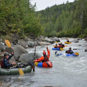 group of six packrafters going down river one at a time
