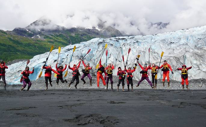 devin-duffy-ak-9.jpg__685x423_q70_crop_subject_location-3237,1715_subsampling-2 A course jumps together with their sea kayaking paddles on a beach in Alaska.