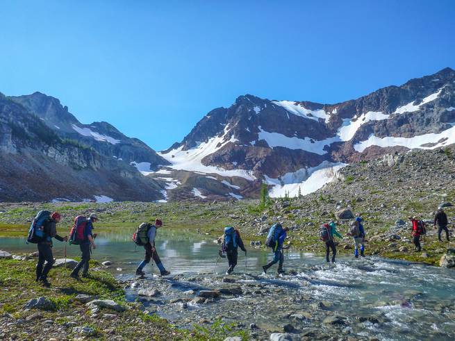 eric-page-.jpg__655x5000_q70_subject_location-895,2000_subsampling-2 Naval Academy Mountaineering course participants cross a stream while backpacking.