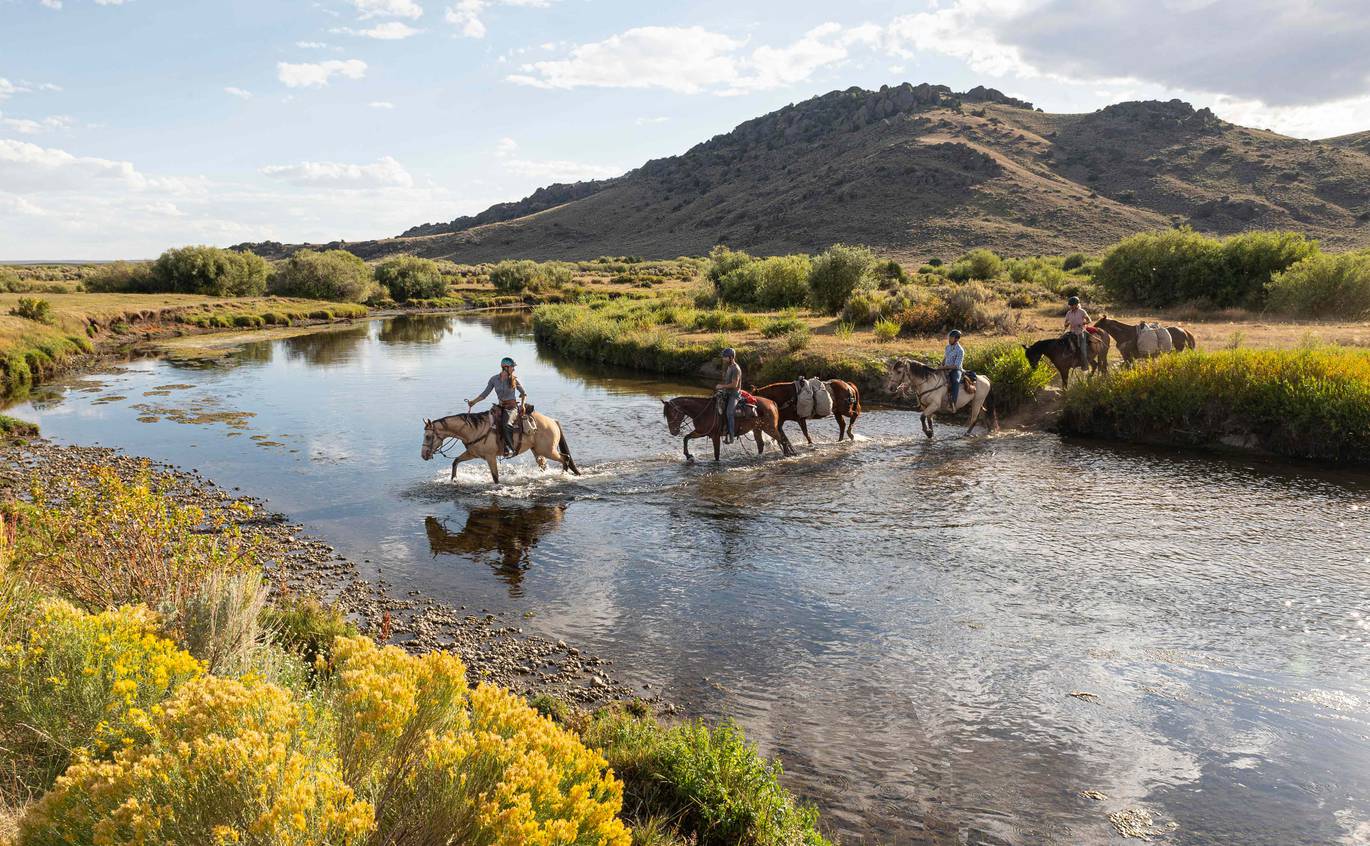 matt_hage_horsepacking-1.jpg__1370x846_q70_crop_subject_location-1684,1437_subsampling-2 Four course participants crossing a river on horseback in Wyoming's backcountry.
