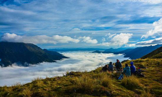 nick-garrett-nz-5.jpg__655x5000_q70_subject_location-437,207_subsampling-2 Course participants sit on a grassy ridge above the clouds in Kahurangi National Park.