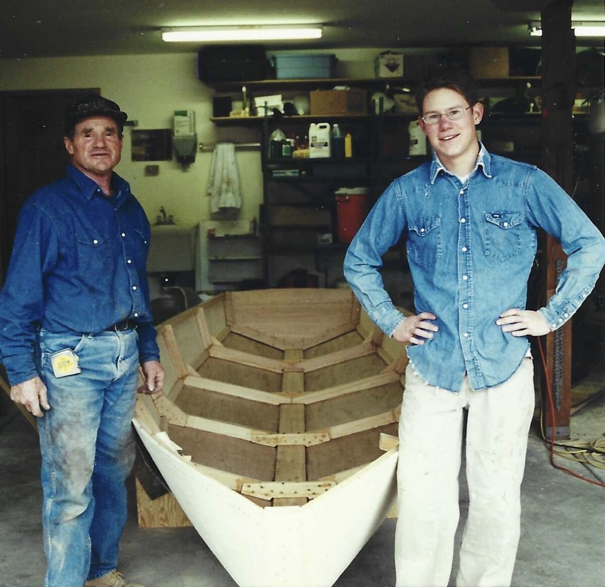 Nick Braun and his father as they build Nick's sailboat in the garage.