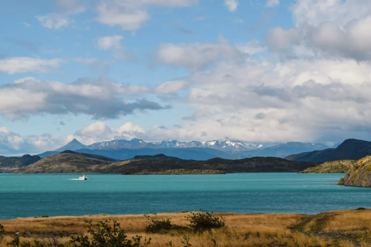 a turquoise ocean with mountains in the background