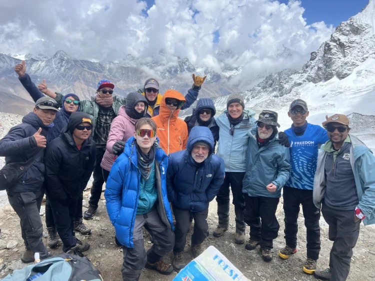 The hiking group smiles at the top of a pass approaching Everest