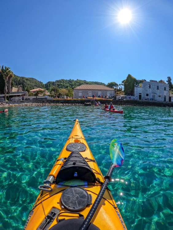 A boat points towards shore in clear blue water in Croatia