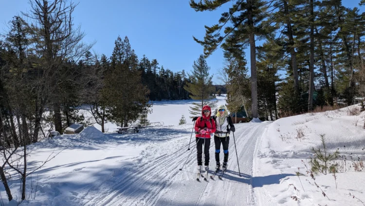 Nordic skiers smile on the trail in Maine