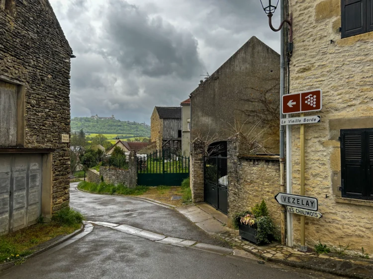 old brick buildings with a cobblestone street winding between them. the sky in the background is grey