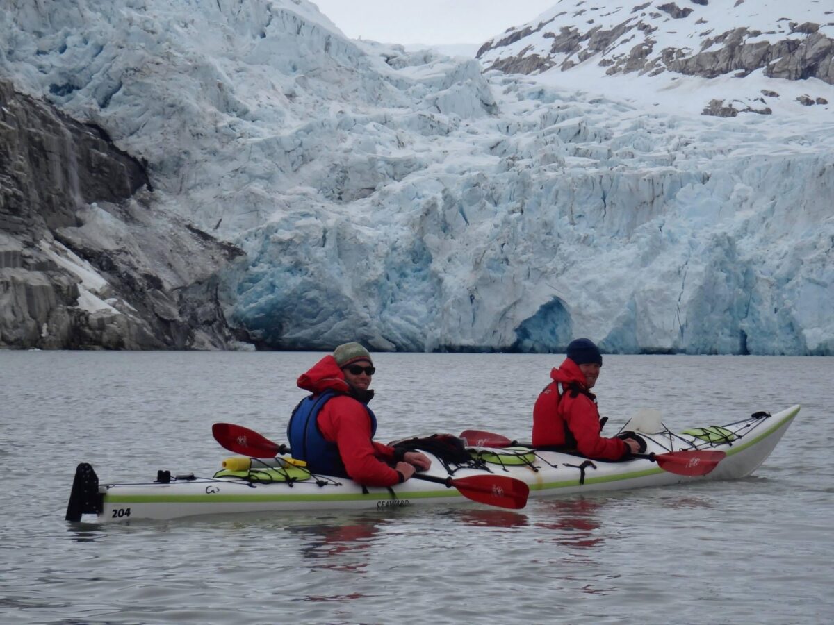Asa and a course mate kayaking with glaciers behind them.