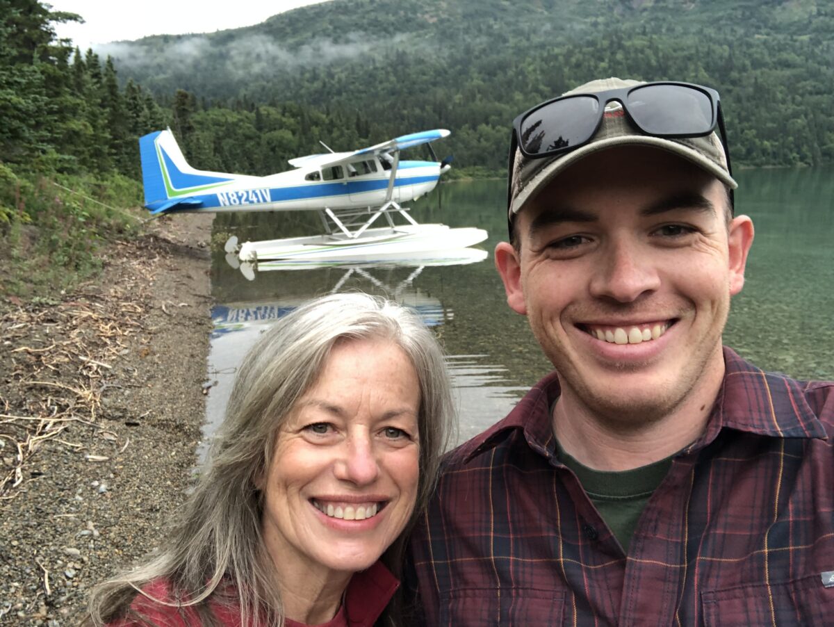 Asa and his biggest fan, his mother, pose in front of an airplane.