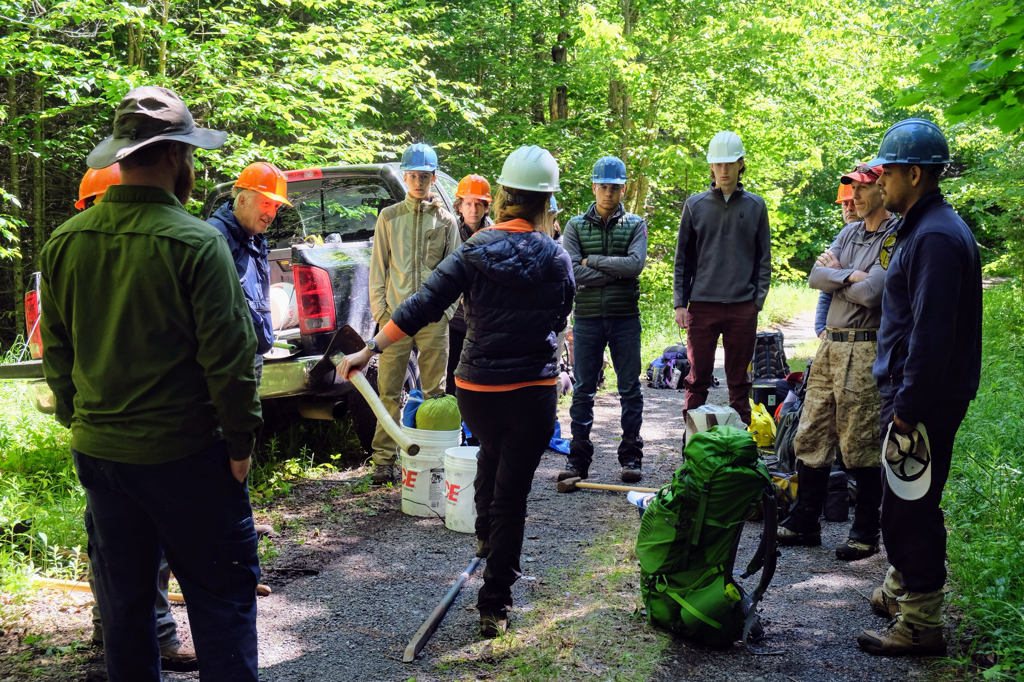 a group of people wearing helmets look at someone for direction