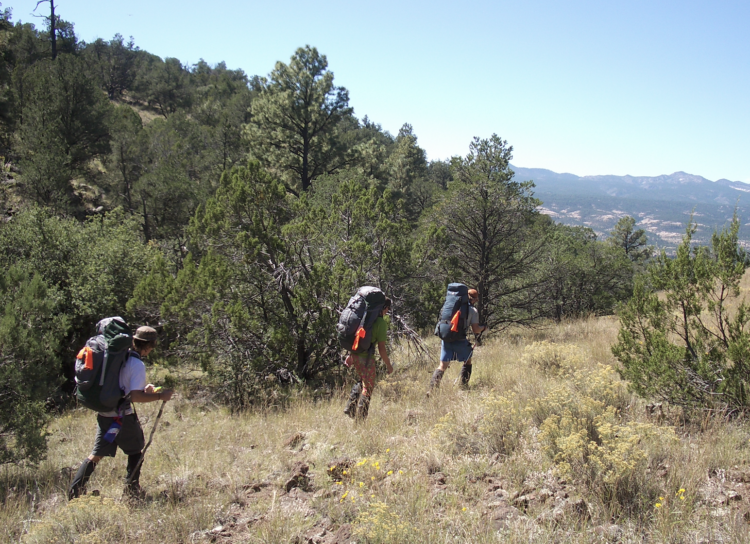 A trio of hikers with packs.