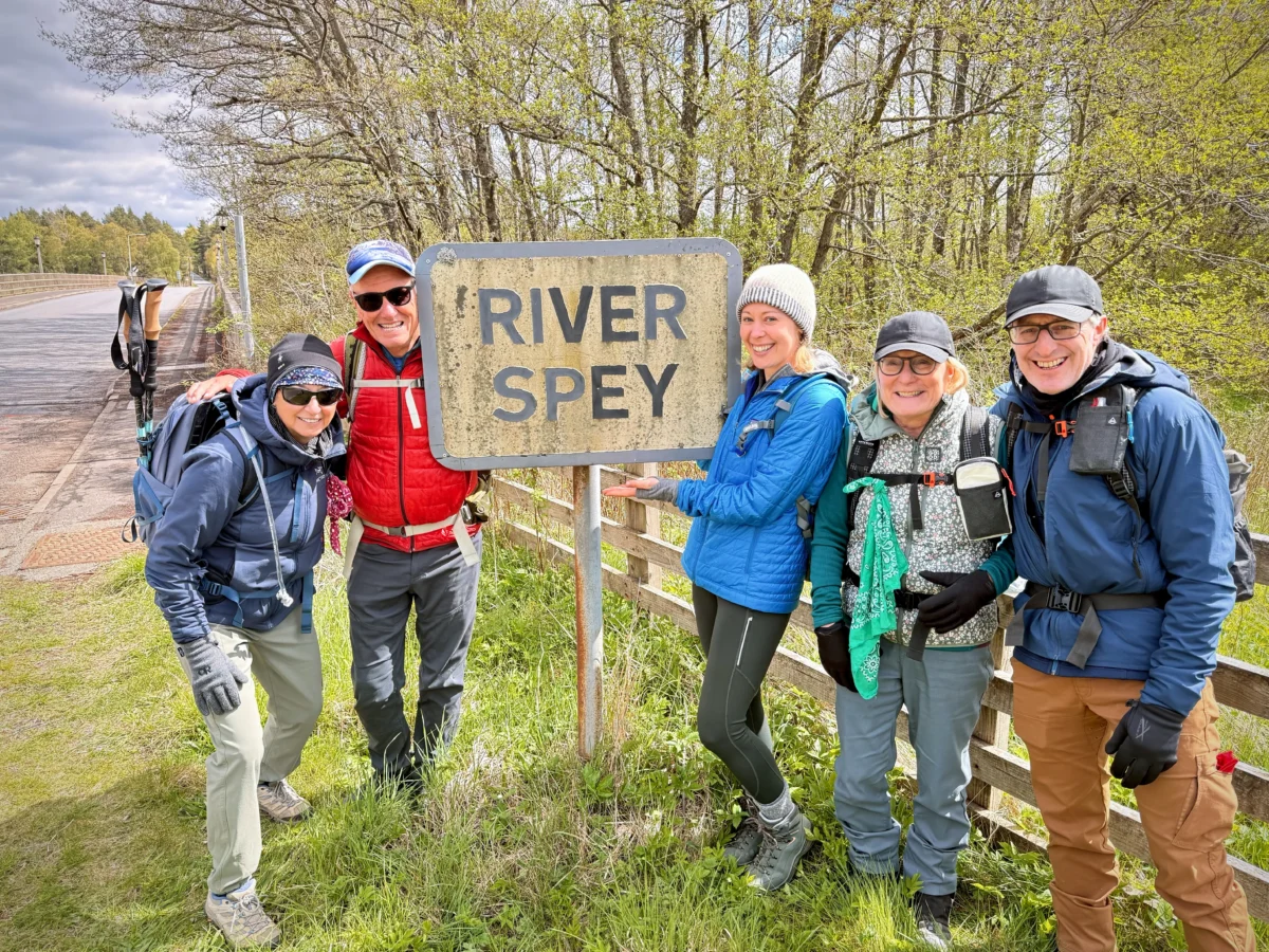 Hikers pose next to a River Spey sign in Scotland