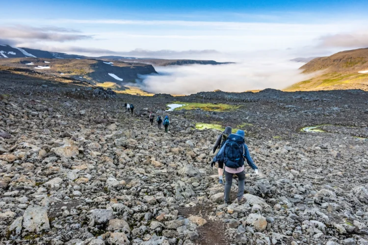 Hikers walk across rocks in Iceland