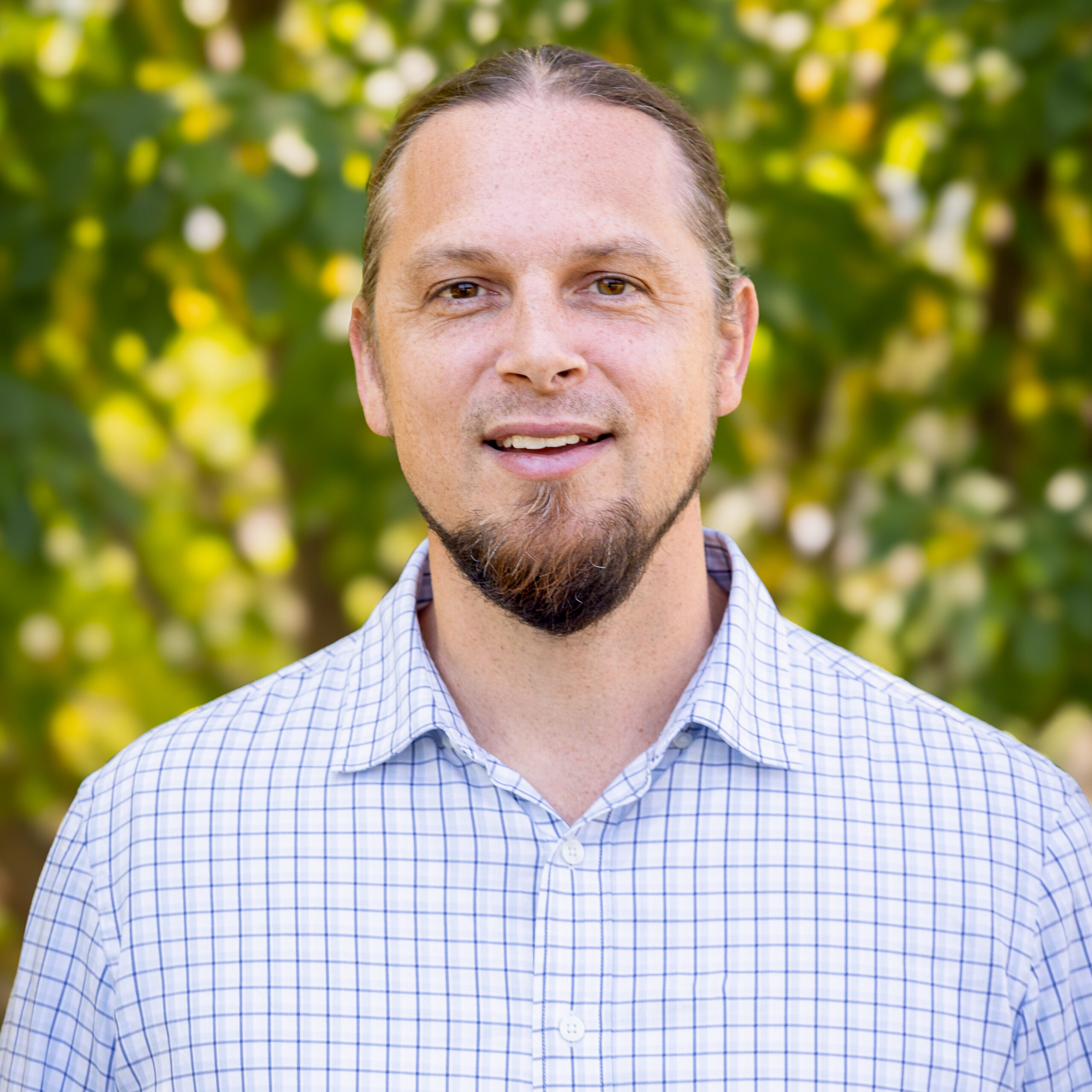 A man with a brown beard smiles at the camera