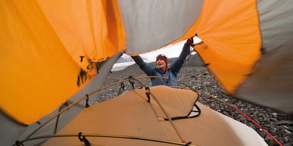 alaska-36-1edited_sized_print.jpg__1400x503_q70_crop_subject_location-2700,1800_subsampling-2_upscale A student throws a tarp over their tent in the process of setting up camp in Alaska.